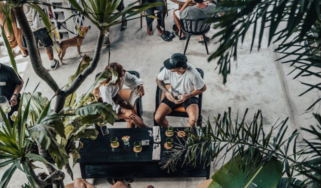Person enjoying a meal at Suburbia café with raw concrete interior