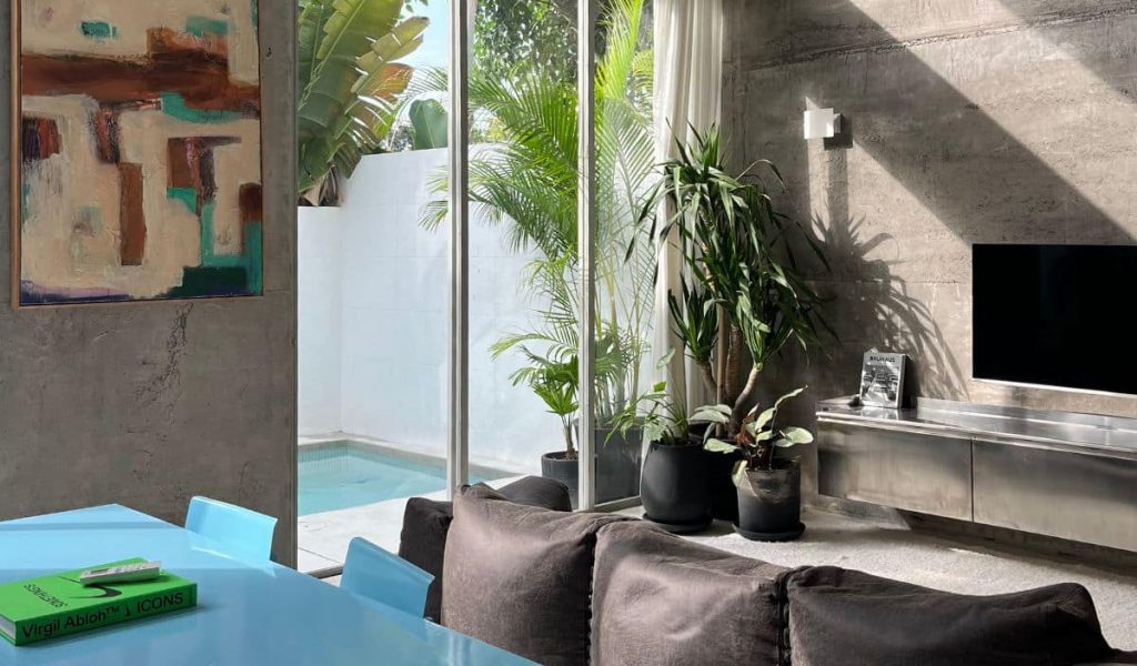 Industrial living room at Sojourn Spaces with concrete walls and modern decor