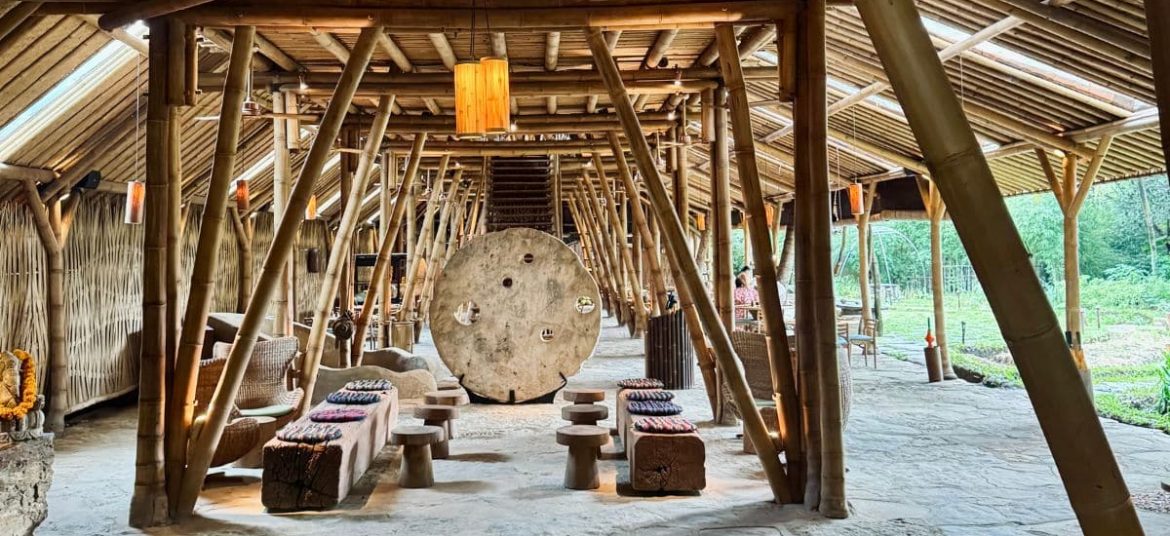 Open-air bamboo restaurant surrounded by lush greenery at Bambu Indah, Ubud